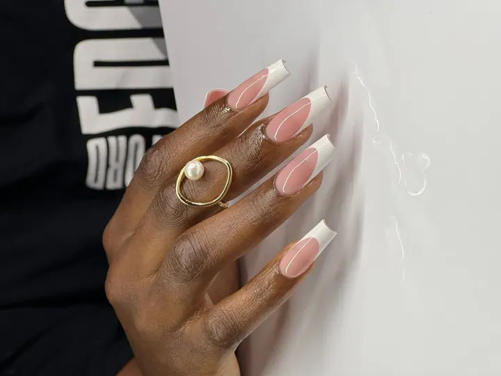Long square French tips with crisp white smile lines and a pearl ring