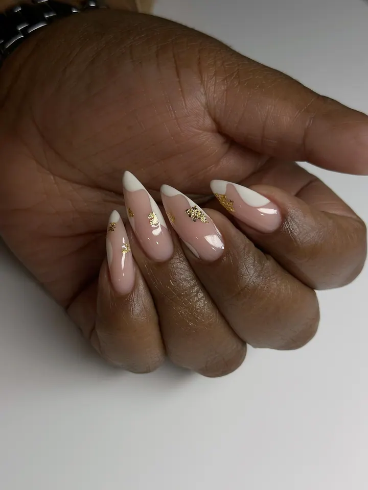 Extra-long stiletto nails, nude with white wave tips and gold leaf